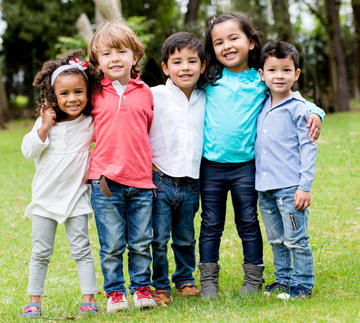 Photo of smiling preschool students standing together.