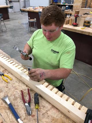 A Tech Center student works on the reconstructing the trim