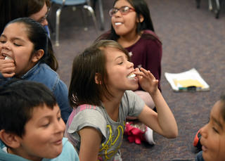 Girl holding a marshmallow in her mouth